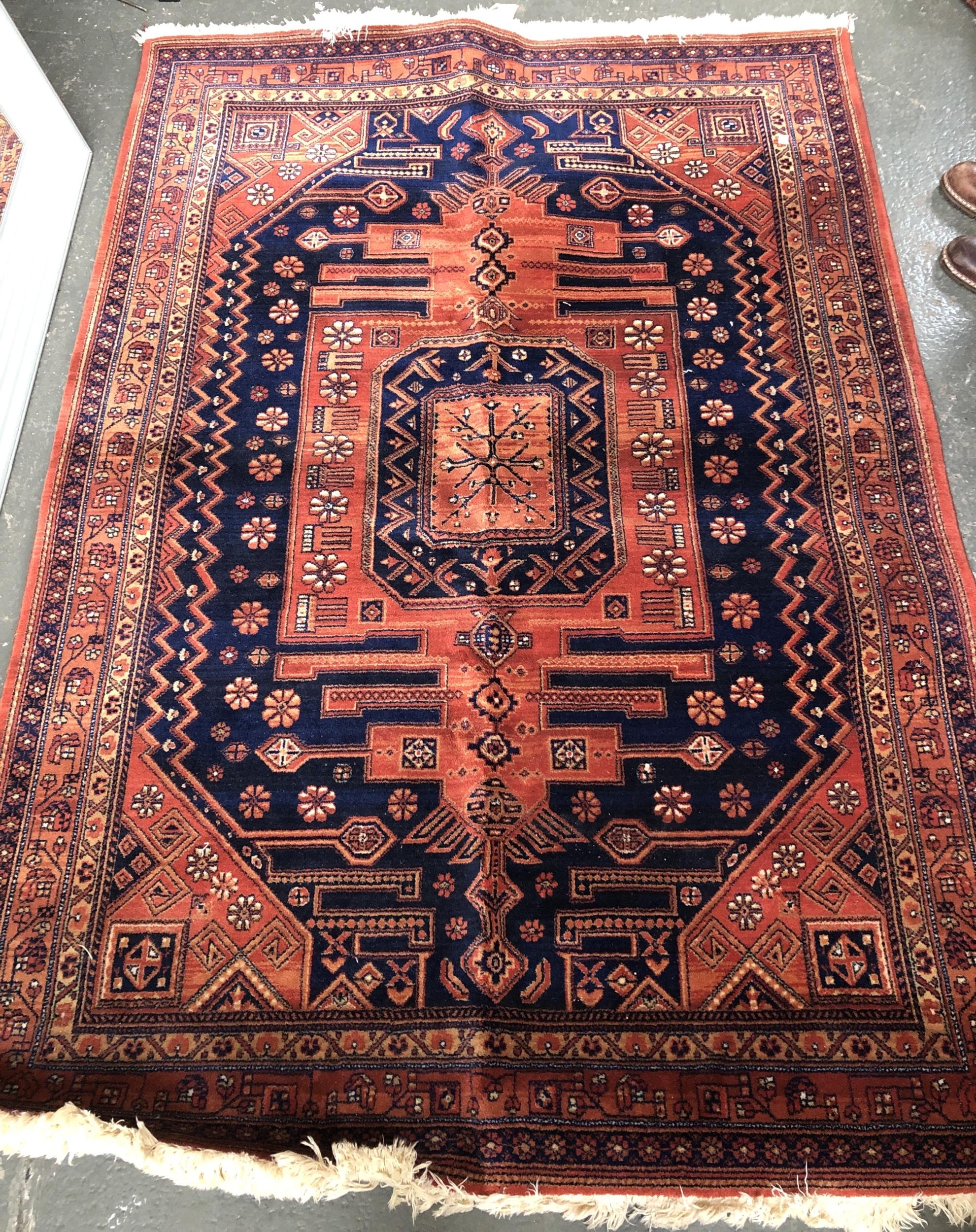 A machine made wool rug, in orange and blue, 138x194cm