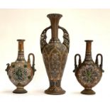 Three c.1900 German stoneware vases, with polychrome decoration, the tallest twin handled vase