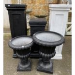 Three fibre glass plinths, 76cm, 102cm and 102cmH, together with two black fibre glass planters in