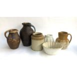 Two terracotta jugs, the larger 30cmH; together with two ceramic jelly moulds, a stoneware jar,