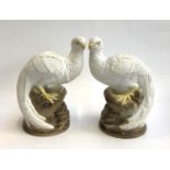 A pair of continental glazed bird figures, each perched on a rocky outcrop, 26cmH