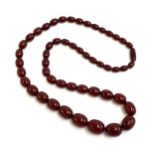 A cherry amber bakelite graduated bead necklace, the largest bead 2.5cm long, total length 89cm