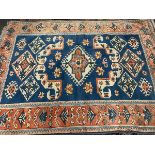 A large wool Persian style rug, central serrated lozenge on a blue ground, 255x185cm
