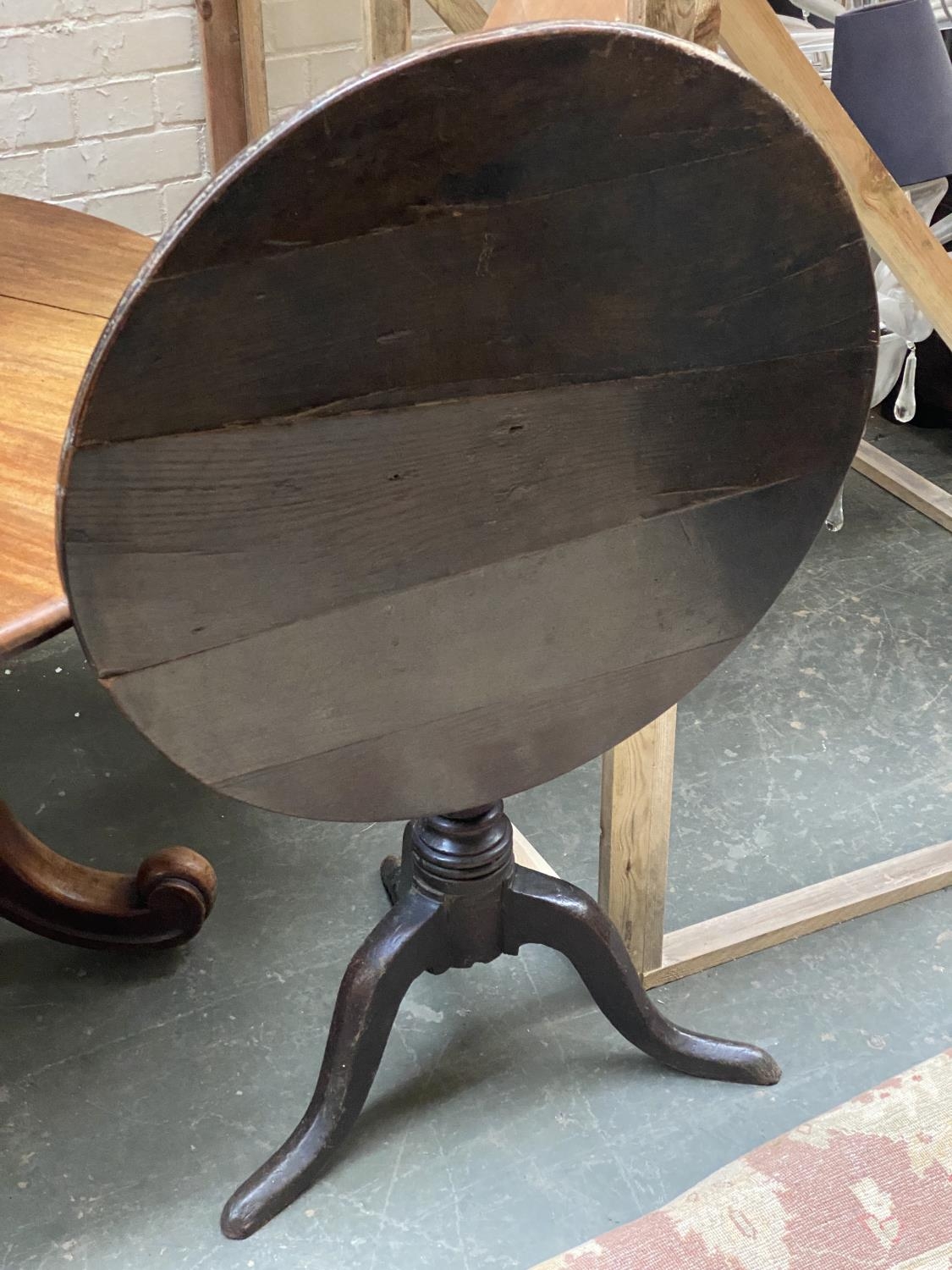 A country made oak tripod table, the tip-top on a turned column with three cabriole legs (one foot