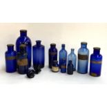 Twelve blue glass drug bottles, the largest 27cmH