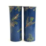 A pair of Maling Art Deco cylindrical vases, with hummingbird pattern against a blue ground,