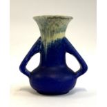 An Arts and Crafts twin handled Ruskin pottery vase glazed in blue with yellow and blue mottled