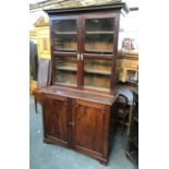 A George III mahogany library bookcase, dentil cornice over two glazed doors, opening to three