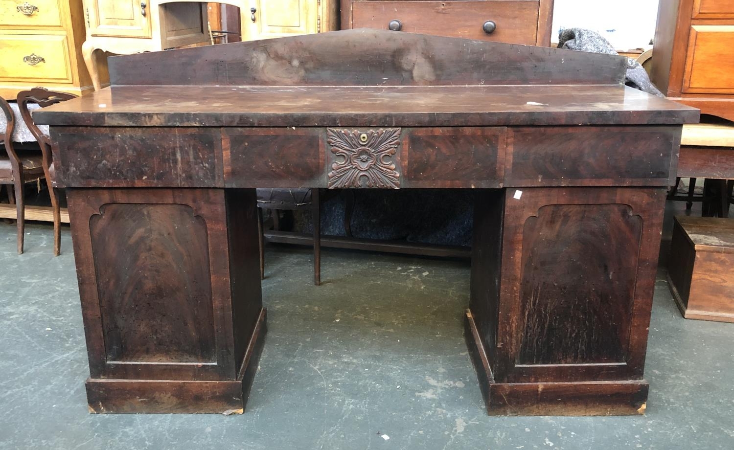 A large Victorian mahogany pedestal sideboard, three drawers, the central drawer with carved