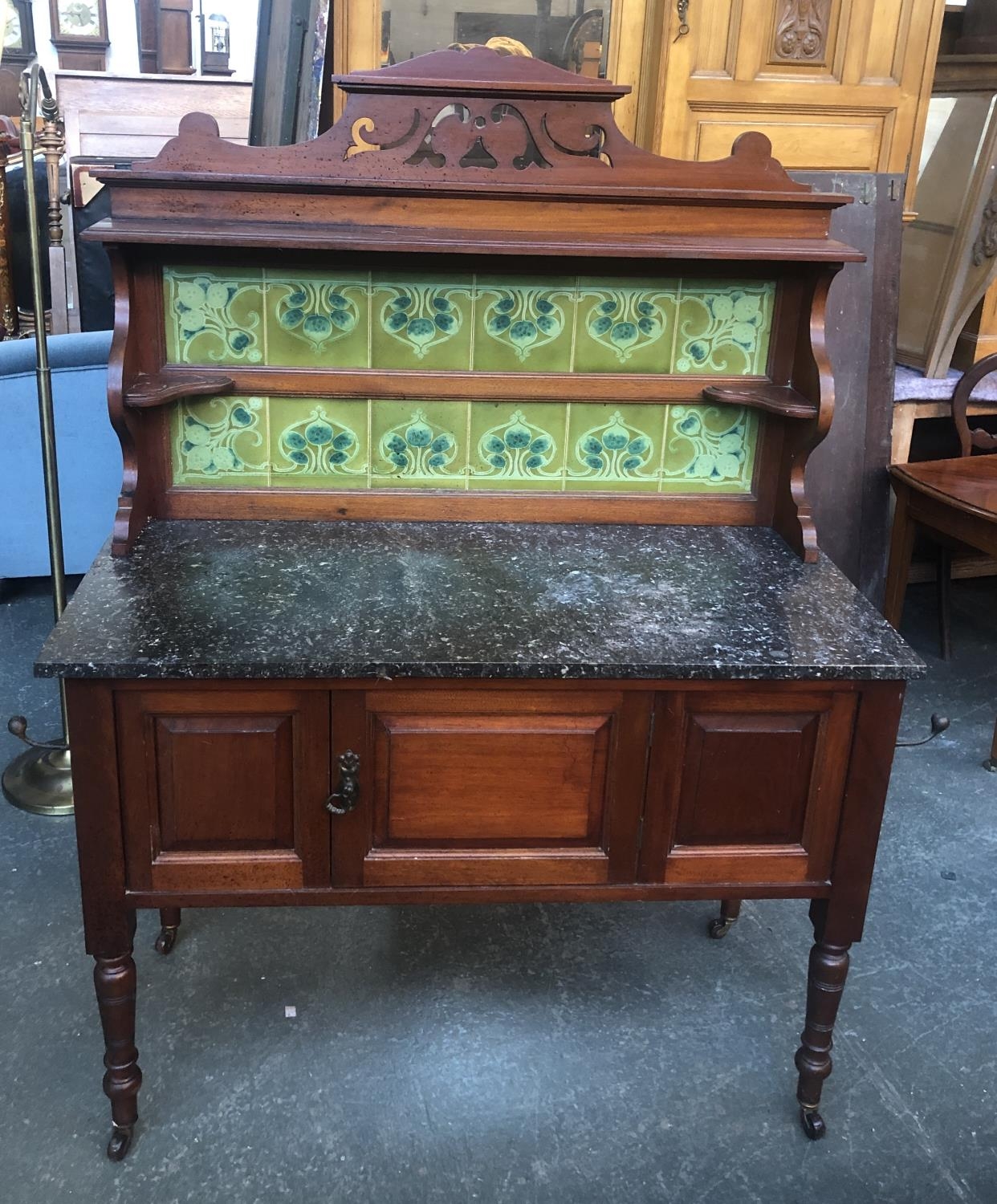 A mahogany wash stand, with tiled upstand and marble top, with single pot cupboard, on turned legs