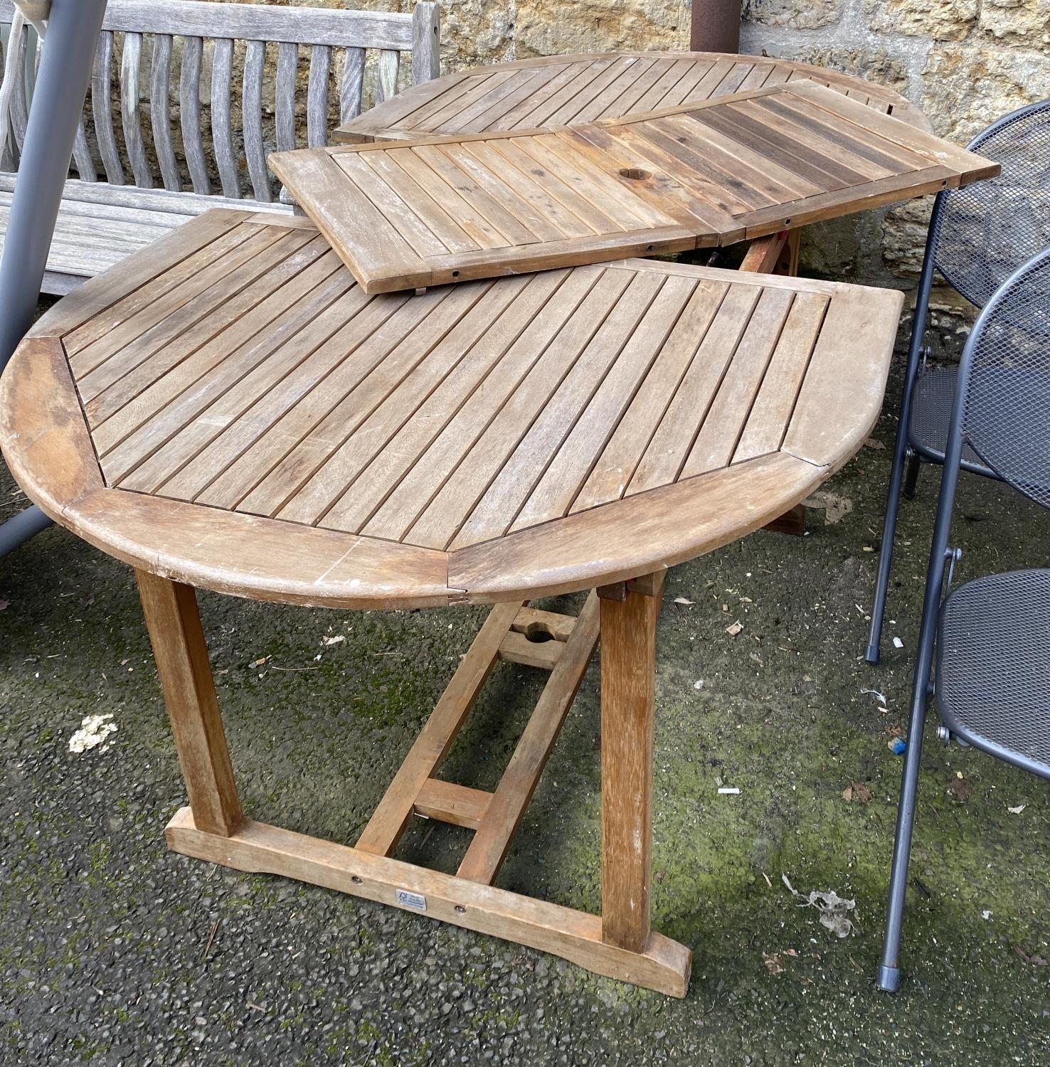 A slatted teak garden table, extending, with single spare leaf