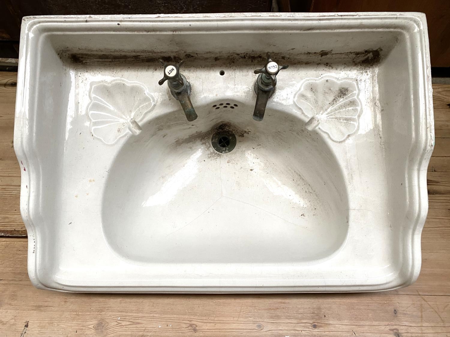 An early 20th century wash basin, with brass taps and plughole, with cast metal wall mount (af), - Image 2 of 3