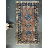 A West Persian rug with three central lozenges, 97x177cm