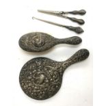 A chased silver looking glass, together with a chased silver clothes brush, button hook, and tongs