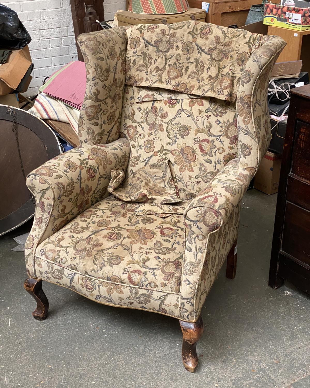 A 20th century George I style wingback armchair with floral upholstery, on cabriole front legs,