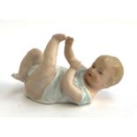 A Gebrüder Heubach bisque porcelain figure of a baby with leg in air, stamped to base, approx. 13.
