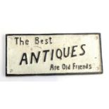 A cast iron sign 'The Best Antiques Are Old Friends', 10.5x23.5cm