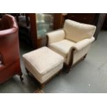 A beech armchair and foot stool of recent manufacture, upholstered in cream stripe woven fabric, the