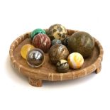 A collection of 13 mineral and other orbs, to include malachite, quartz etc, within a wicker basket