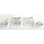 Two Kosta Boda square glass dishes, each 10cm square, together with two glass candle stick