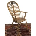 A 19th century ash and elm splatback windsor armchair, on ring turned legs and H stretcher, rear leg