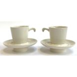 A pair of unusual ceramic coffee cups and saucers with rounded spiked bases