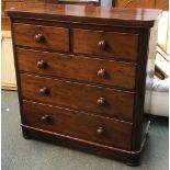 A Victorian mahogany chest of two short over three graduating drawers, with turned wooden knobs,