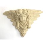 A cast stone wall bracket in the form of a putti, 31cmH 46cmW