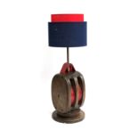 A vintage rope pulley converted for use as an electrical lamp with red and blue shade, 69cmH