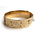 A LW&G 9ct gold bronze core lagarmic bangle, with engraved design, 52.3g