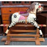 A large dapple grey rocking horse with painted features, brown horsehair mane and tail, leather