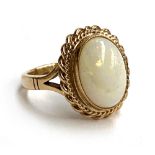 A 9ct gold ring set with an opal cabochon with a rope twist border, size P, 6.1g