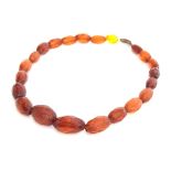 A faceted amber bead necklace, with a 9ct gold clasp, the largest bead 2.7cm long (one bead yellow