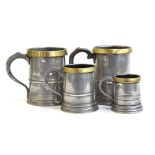 Four pewter and brass tankards, the pint and half pint marked J Shimeild, Southgate to base, quart