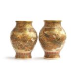 A pair of Meiji period Japanese Satsuma vases, of baluster form, decorated with immortals and panels