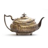 A George III silver teapot by Solomon Hougham, London 1815, with part fluted body, the scroll handle