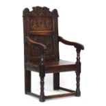 A Charles II oak wainscot chair, the shaped cresting carved with a flowering vine over two panels