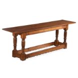 An oak serving table in late 17th century style, on turned supports and shaped peripheral