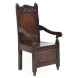 A Charles II oak child's chair, with a carved cresting rail over a simple rectangular panelled back,