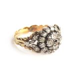 A 19th century diamond cluster ring, the diamonds set in silver with a foliate engraved gold band