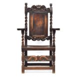 A Charles II oak armchair, c.1670, of unusual form, the rectangular panelled back surmounted by a
