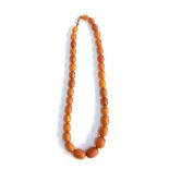 An amber bead necklace, the largest of the graduated beads 1.9cm wide, the smallest 1cm wide, with