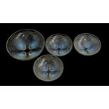 A set of four Lalique opalescent glass bowls, the larger 18cm diameter, the three smaller 13cm