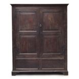 An 18th century provincial oak cupboard, moulded pediment over a pair of panelled doors, opening