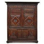 A 17th century and later carved oak cupboard, two doors with lozenge and demilune carving, opening