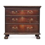 An early 18th century and later oak chest of drawers, the top with heavy moulding, over three