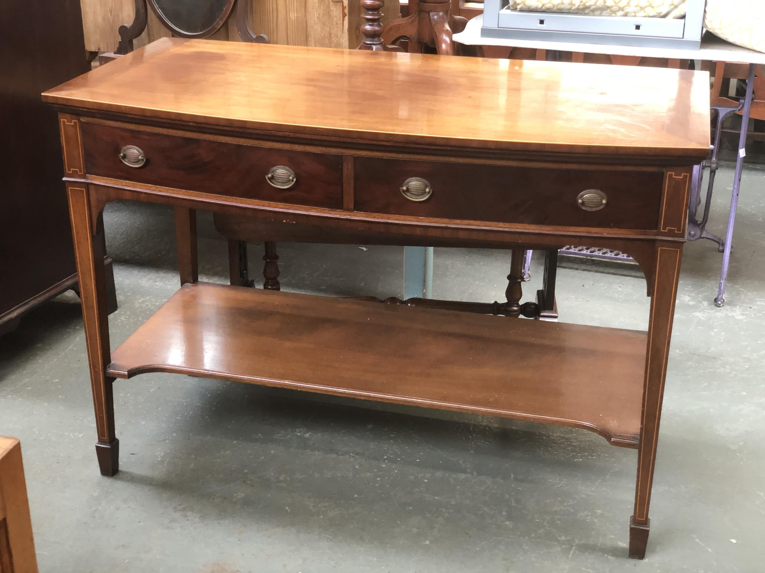 An early 20th century mahogany bowfront side table, two frieze drawers and undershelf, on square