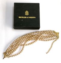 A Butler & Wilson faux pearl six strand necklace, in original box bearing Harrods label, 41cmL