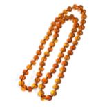 A long string of amber beads, knotted, each bead approx. 1.4cmW, one bead cracked, approx. 95g, 50cm