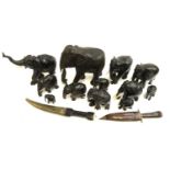 A quantity of carved ebony elephant figurines; together with two tribal daggers